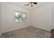 A basic bedroom with neutral carpet, a window with blinds and a ceiling fan at 14831 Charterhouse Ln, Huntersville, NC 28078