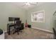 This bedroom has neutral carpets, a desk, a guitar, and a ceiling fan at 14831 Charterhouse Ln, Huntersville, NC 28078
