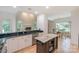 Open-concept kitchen with an eat-in island, bright white cabinets and black countertop at 14831 Charterhouse Ln, Huntersville, NC 28078