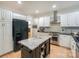 Spacious kitchen with white cabinets, stainless steel appliances, and a black refrigerator at 14831 Charterhouse Ln, Huntersville, NC 28078