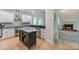 Open kitchen area showing eat-in island and opening into a living space with fireplace at 14831 Charterhouse Ln, Huntersville, NC 28078