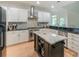 Bright kitchen with white cabinetry, stainless steel appliances, and center island with marble countertop at 14831 Charterhouse Ln, Huntersville, NC 28078