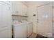 Efficient laundry room features a washer, dryer, and ample storage space with white cabinets at 14831 Charterhouse Ln, Huntersville, NC 28078