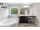 A full bathtub in a full bathroom with tiled floors and a wide vanity area at 15416 Oleander Dr, Charlotte, NC 28278