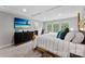 Bedroom featuring tray ceiling, large bed, mounted TV, and plenty of windows at 15416 Oleander Dr, Charlotte, NC 28278