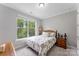 Cozy bedroom with floral bedding and plenty of natural light from the window at 15416 Oleander Dr, Charlotte, NC 28278