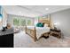Spacious bedroom with tray ceiling, wooden bed frame and seating area at 15416 Oleander Dr, Charlotte, NC 28278