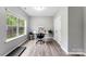 Bright office with hardwood floors, a large window, white desk, and a neutral color palette offers a serene workspace at 15416 Oleander Dr, Charlotte, NC 28278