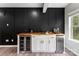 Modern wet bar features sleek black accent wall, butcher block countertop, wine cooler, and stainless beverage refrigerator at 15416 Oleander Dr, Charlotte, NC 28278