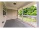 View of the covered back porch featuring painted white brick and views into the wooded backyard at 1631 Vancouver Dr, Charlotte, NC 28213