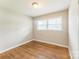 This cozy bedroom features hardwood floors, natural light from the window, and neutral walls at 1631 Vancouver Dr, Charlotte, NC 28213