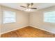 This bedroom has a ceiling fan, two windows, and hardwood floors for comfort and style at 1631 Vancouver Dr, Charlotte, NC 28213