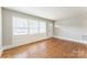 Bright living room featuring hardwood floors, large windows, and fresh paint, offering a clean and welcoming space at 1631 Vancouver Dr, Charlotte, NC 28213