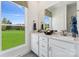 Bright bathroom with double sinks, white cabinets, quartz countertops, and a view of the beautiful green space at 1940 Westerhill Dr, Fort Mill, SC 29708