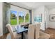 Bright dining room features large windows with a view of the manicured lawn and black table with white chairs at 1940 Westerhill Dr, Fort Mill, SC 29708