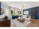 Spacious living room with blue accent wall, modern lighting, and ample seating with a view of the backyard at 1940 Westerhill Dr, Fort Mill, SC 29708