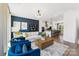 Open-concept living room flows into kitchen, featuring a stylish blue accent wall and modern decor and lots of seating at 1940 Westerhill Dr, Fort Mill, SC 29708