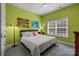 Green-walled bedroom featuring a white bed, colorful art, and a window with blinds, blending style and comfort at 2009 Waterbury Ln, Waxhaw, NC 28173