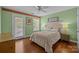 Cozy bedroom with hardwood floors, a ceiling fan, and a sliding glass door to a balcony at 2009 Waterbury Ln, Waxhaw, NC 28173