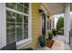 A cozy front porch with seating, potted plants, and a brown door with glass panes at 2009 Waterbury Ln, Waxhaw, NC 28173