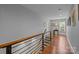 Upstairs hallway featuring hardwood floors, neutral paint, and natural light at 2009 Waterbury Ln, Waxhaw, NC 28173