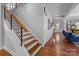 Hallway with hardwood floors, modern railing, and views into a sitting room at 2009 Waterbury Ln, Waxhaw, NC 28173