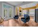 Bright, open-concept living area with hardwood floors, blue accent chairs, and a partial view of the kitchen at 2009 Waterbury Ln, Waxhaw, NC 28173