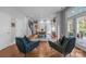 Open living space flowing into the dining area, featuring hardwood floors, stylish furniture, and natural light at 2009 Waterbury Ln, Waxhaw, NC 28173