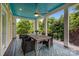 Covered outdoor deck with dining table, four chairs, ceiling fan, and a view of the surrounding greenery at 2009 Waterbury Ln, Waxhaw, NC 28173