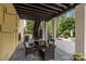 Covered outdoor dining area with wicker furniture and a view of the landscaped backyard at 2009 Waterbury Ln, Waxhaw, NC 28173