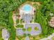 Aerial view of a community pool area, surrounded by lush trees, walking paths, and parking at 2010 Brightflower Ln, York, SC 29745