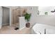 Bright bathroom with frameless glass shower and soaking tub next to a bright window with plants at 2010 Brightflower Ln, York, SC 29745