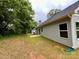 A view of the backyard and the side of the house, featuring some trees at 212 Queens Ct, Gastonia, NC 28052