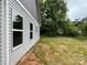 A side view of the home reveals vinyl siding and windows facing the spacious backyard at 212 Queens Ct, Gastonia, NC 28052