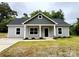 Charming gray home featuring a covered front porch with stately columns and a well-manicured lawn at 212 Queens Ct, Gastonia, NC 28052