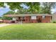 Charming brick home with a well-manicured lawn, classic car, and inviting front porch at 2210 Joes Lake Rd, Shelby, NC 28152