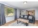 Bright living room with a gray couch, wood floors, large window, and neutral decor at 2210 Joes Lake Rd, Shelby, NC 28152
