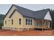 Rear exterior view of a newly constructed home featuring modern design elements, a partially covered porch, and a well-lit backyard at 2589 Polo Ln, Maiden, NC 28650