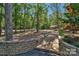 Landscaped backyard features a stone retaining wall and walkway, enhancing the natural beauty at 2709 Blythe Rd, Waxhaw, NC 28173