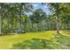 Expansive backyard featuring mature trees, a lush green lawn, and some equipment ready for use at 2709 Blythe Rd, Waxhaw, NC 28173