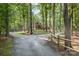 Scenic driveway leading to a beautiful log home surrounded by trees at 2709 Blythe Rd, Waxhaw, NC 28173