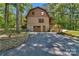 View of exterior of home, with stone accents, lush landscaping and a paved driveway at 2709 Blythe Rd, Waxhaw, NC 28173