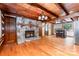 Open living space with stone fireplace, wood ceilings and kitchen with island seating at 2709 Blythe Rd, Waxhaw, NC 28173