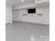 Spacious living space with built in storage, a television, and light gray epoxy floors at 2709 Blythe Rd, Waxhaw, NC 28173