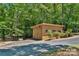 Charming outbuilding with double doors on a paved driveway and surrounded by a lush, wooded landscape at 2709 Blythe Rd, Waxhaw, NC 28173