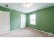 Bedroom features neutral carpet, ample natural light, and green painted walls at 3073 Langhorne Sw Ave, Concord, NC 28027