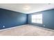 Serene bedroom features neutral carpet, a large window, and a calming blue accent wall at 3073 Langhorne Sw Ave, Concord, NC 28027
