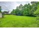 Expansive backyard featuring lush green grass, mature trees, trampoline, and playhouse perfect for outdoor activities and relaxation at 3447 Filbert Hwy, Clover, SC 29710