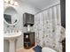 Cozy bathroom with a pedestal sink, decorative mirror, and a shower with a patterned curtain at 3447 Filbert Hwy, Clover, SC 29710