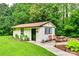 Exterior view of additional living space with a green door, picnic table, and lush greenery, providing a cozy and private space at 3447 Filbert Hwy, Clover, SC 29710